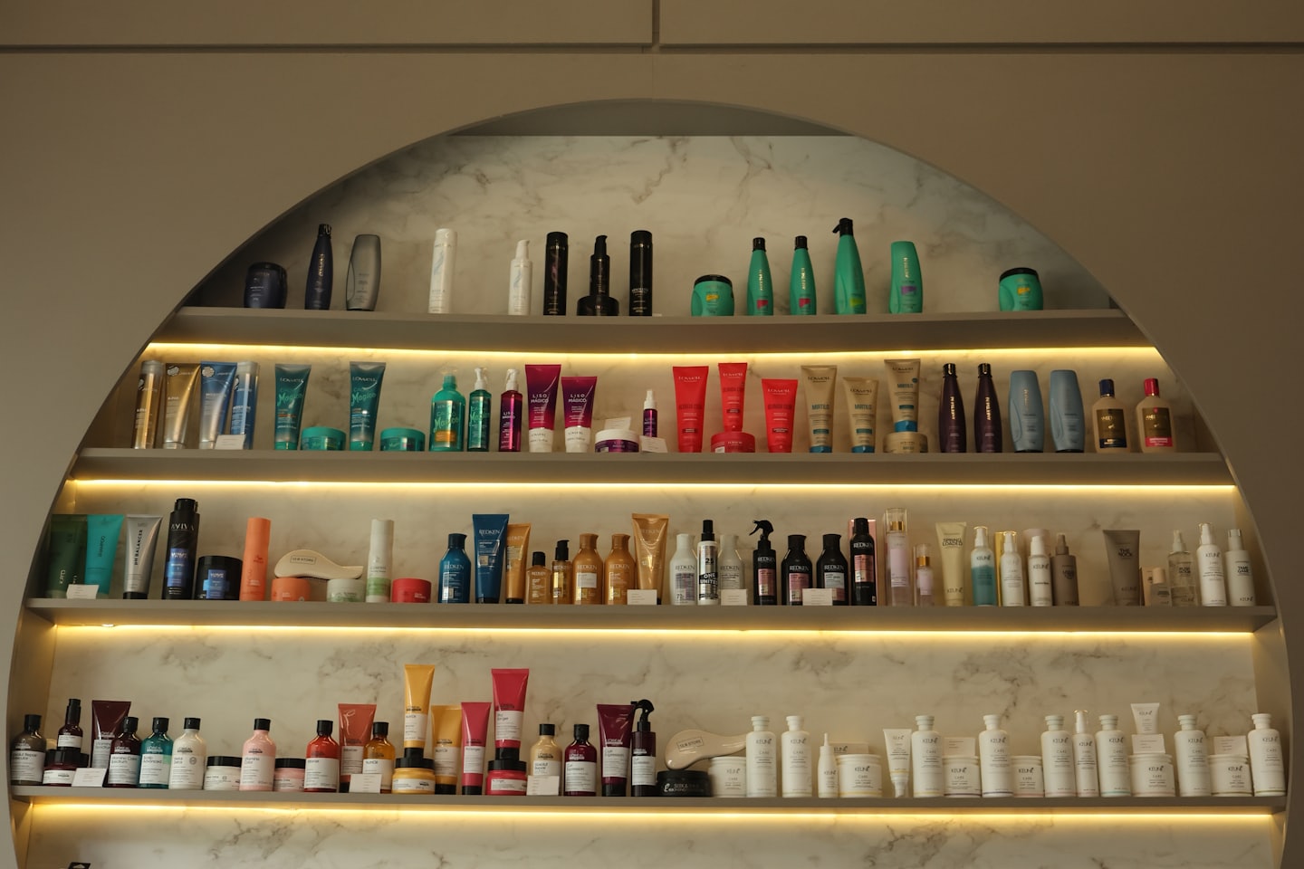 Beauty products lined up on lit shelves in a cosmetics store